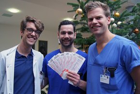 Die Assistenzärzte von "Junge Ärzte Regensburg e. V.", Dr. Valentin Böhm, Dr. Alexander Wiesenberg und Matthias Küsters (v. li.) beschenken Patienten der Barmherzigen Brüder mit Karten für ein Heimspiel des SSV Jahn. (Foto: Julia Gergovich)