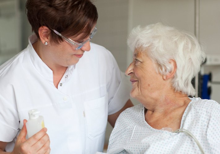 Pflegerin versorgt alte Patientin (Foto: Carolin Jacklin) Pflegerin versorgt alte Patientin