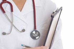 Visite (Foto: Franz Pflügl - Fotolia.com) Man sieht einen Körper, der einen Arztkittel trägt und eine Akte in der Hand hält