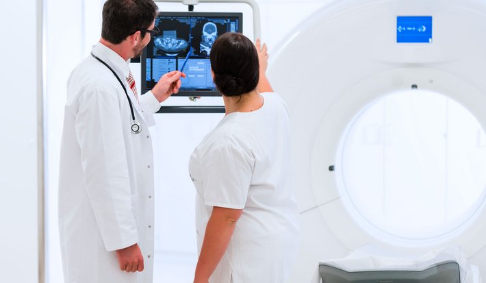 Computertomographie (Foto: Kzenon) Ein Arzt sowie Pflegekraft besprechen das Ergebnis der Untersuchung.