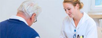 Eine Pflegekraft im Gespräch mit einem unserer stationären Patienten.